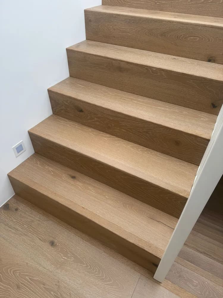 Oak-clad staircase with matching wide-plank oak flooring below