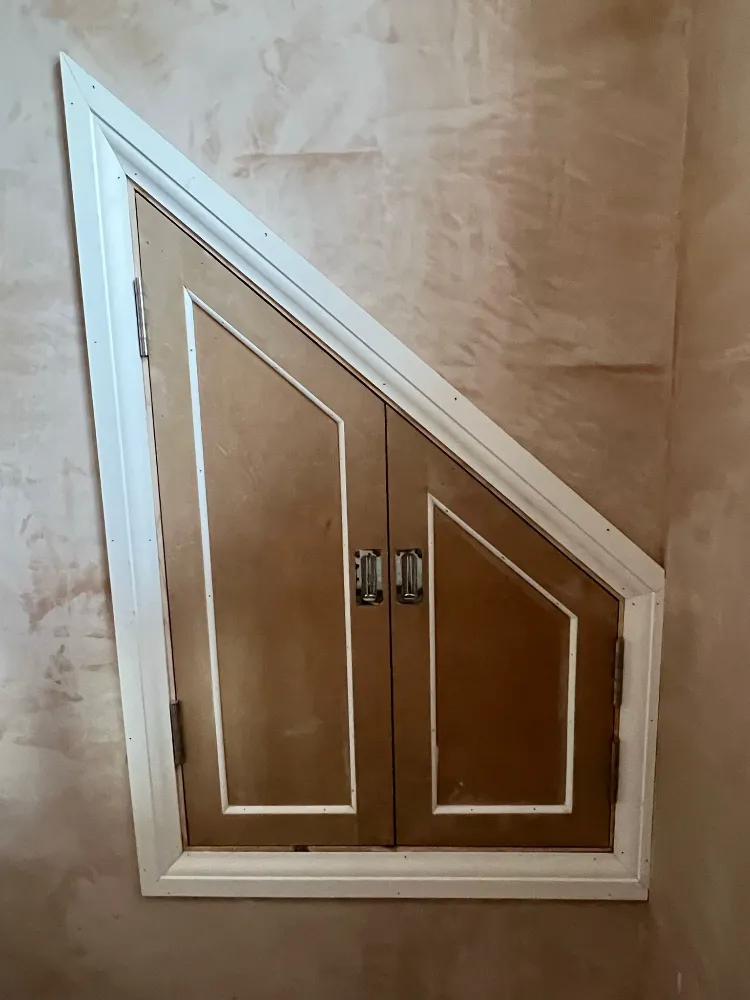 Bespoke triangular cupboard doors fitted into a sloped eaves recess